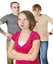 Teen rolling her eyes with parents in the background
